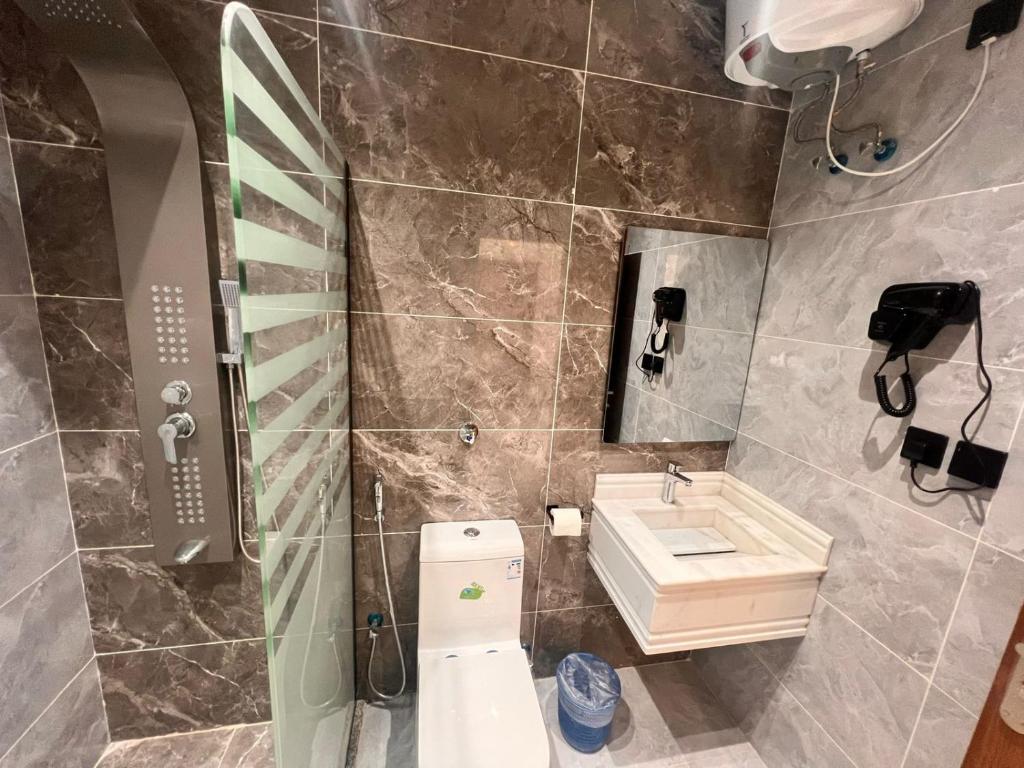 a bathroom with a toilet and a sink at شقة بتصميم انيق ودخول ذاتي ج in Quai