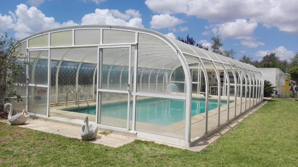 a glass house with a swimming pool in a yard at Quinta Santa Ana in Setúbal