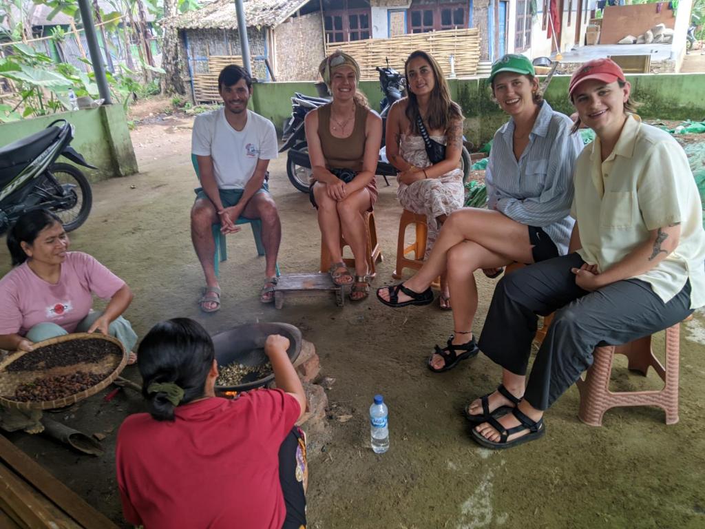 a group of people sitting on chairs in the dirt at Coffee Homestay Tetebatu in Tetebatu