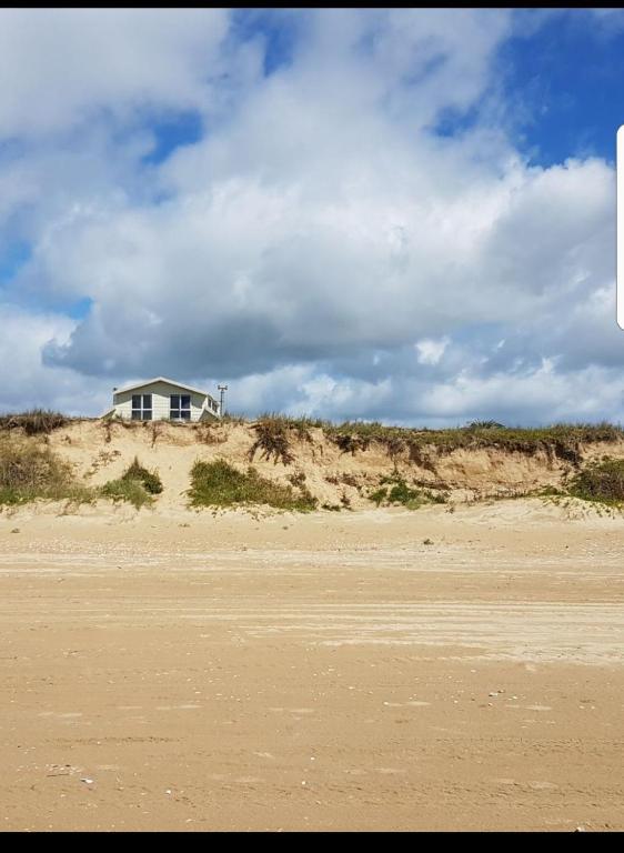 a house on the top of a sandy beach at Pyramid house in Karikari Peninsula