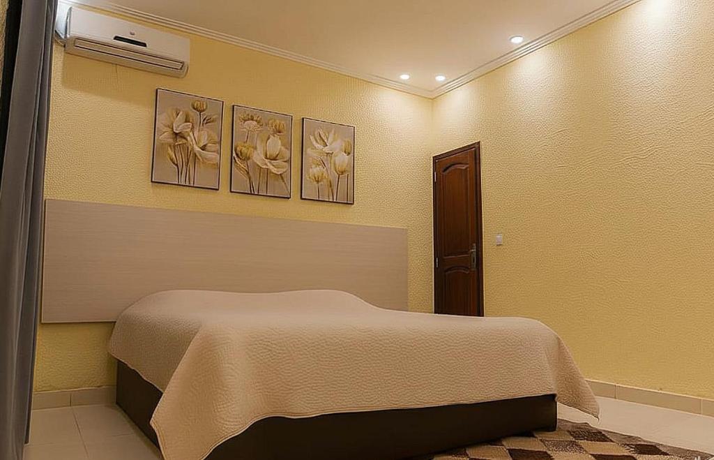 a bedroom with a bed and three pictures on the wall at Beautiful House - COP30 in Belém