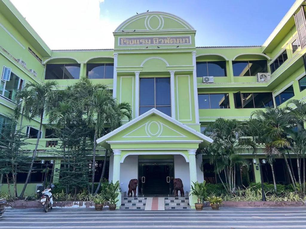 Ein Gebäude mit einem Mann auf einem Motorrad davor. in der Unterkunft New Siya in Maha Sarakham