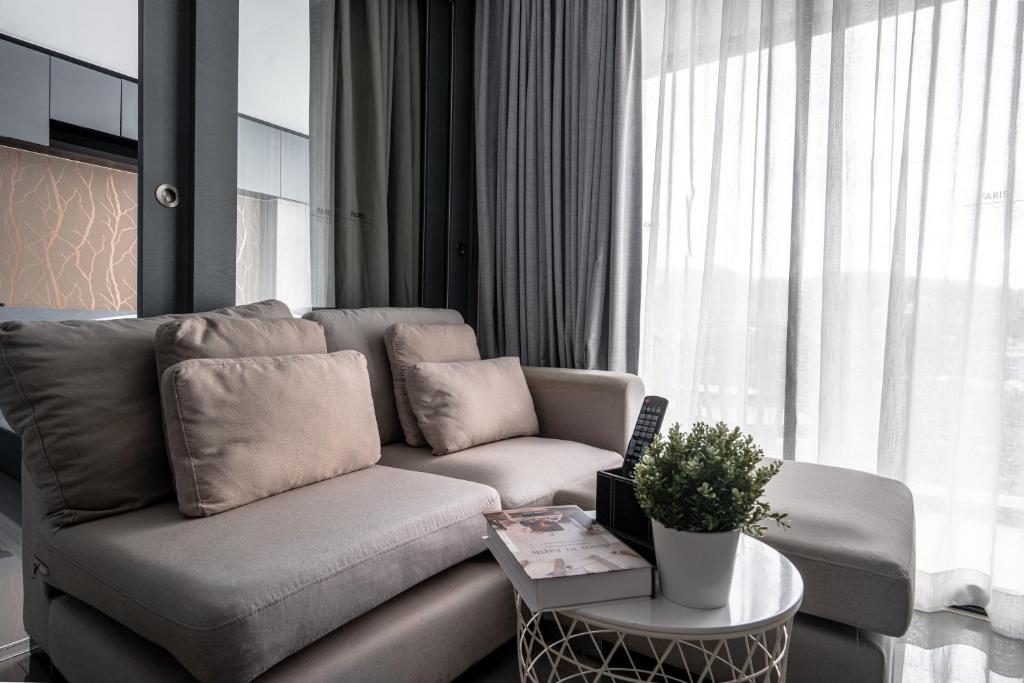 a living room with a couch and a table at Luxury 1BR Resort Retreat by IBG Property P514 in Kamala Beach