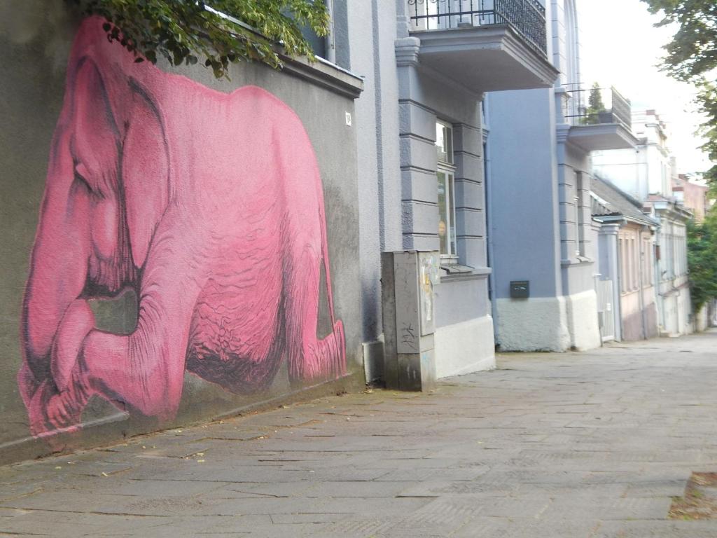 a painting of a pink elephant on the side of a building at ROKO Apartments in Kaunas
