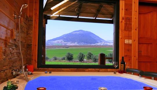 baño con ventana grande y bañera azul en Noach Batavor, en Kefar Qish