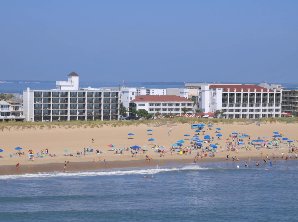 um grupo de pessoas em uma praia com guarda-sóis em Castle in the Sand em Ocean City