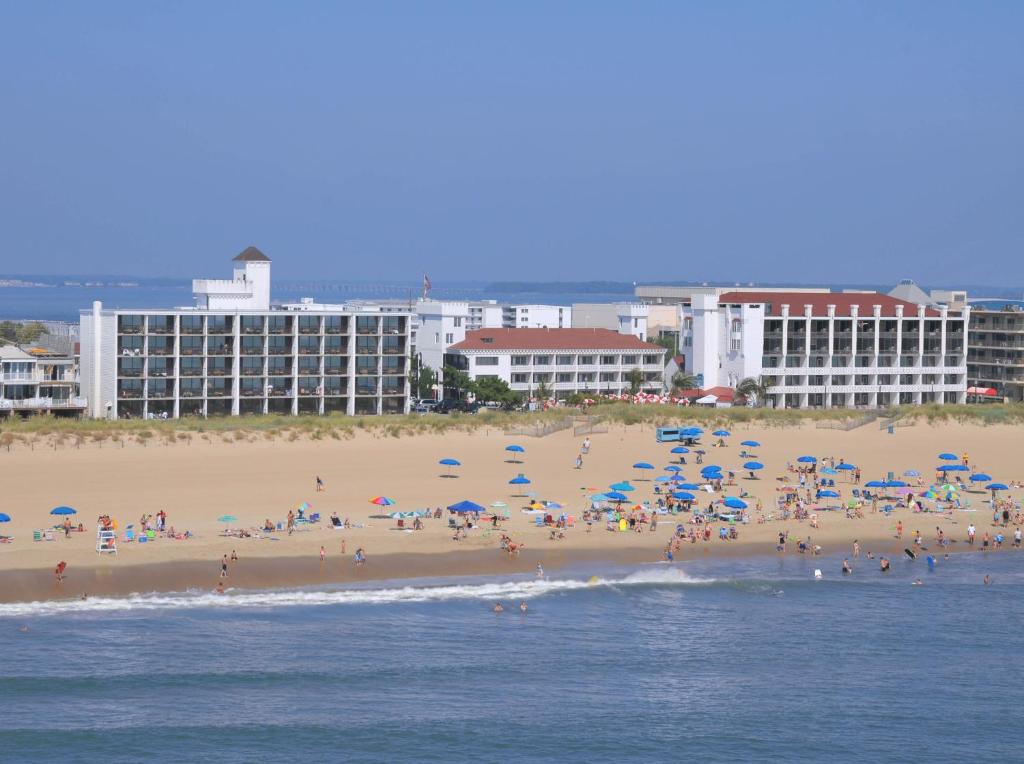 un gruppo di persone su una spiaggia con ombrelloni di Castle in the Sand a Ocean City