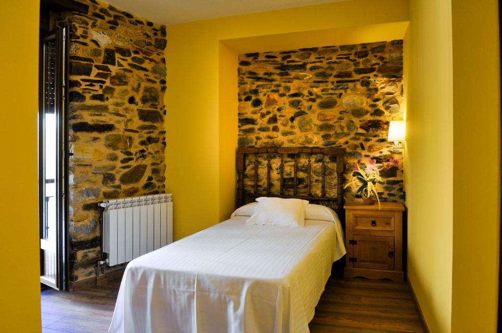 A bed or beds in a room at Hotel Rural Pescadores