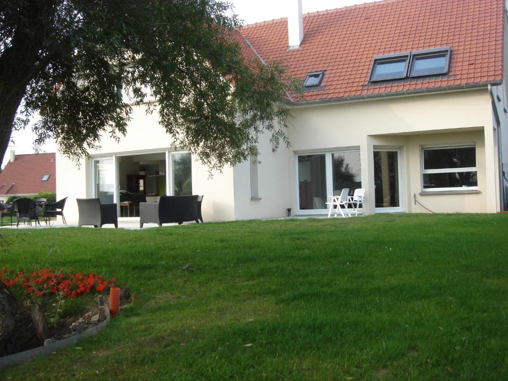 uma casa com um quintal com relva verde em Chambres d'Hôtes La Villa des Hortensias em Berck