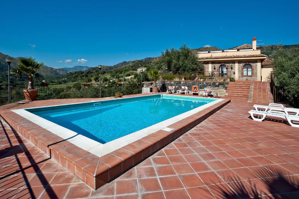 a swimming pool in front of a house at Il Poggio Country Resort in Graniti