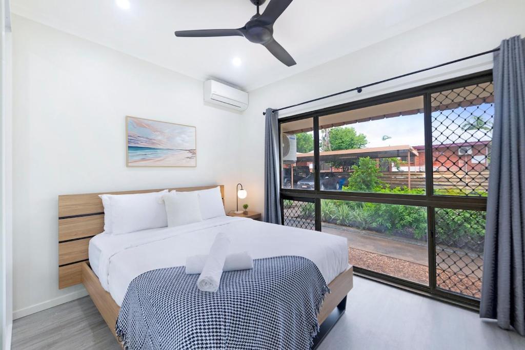 a bedroom with a bed and a large window at Zen Coastal Hideaway 2BR Modern - Hospital - Beach in Casuarina