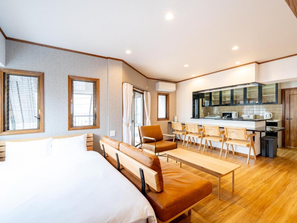 une chambre avec un lit et une salle à manger dans l'établissement The LAMP Minoshima, à Sumiyoshi