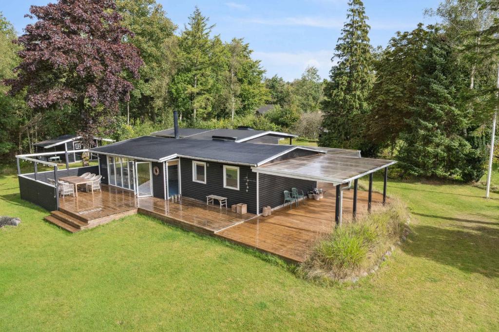 a home with a deck and a house at Renovated Holiday Home Near Water And Nature in Lundø