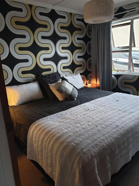 Schlafzimmer mit einem Bett mit einer schwarz-weißen Wand in der Unterkunft Lake Oasis in Queenstown