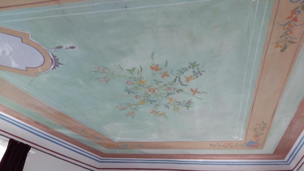 un techo con una pintura de flores. en L'affresco, en La Spezia