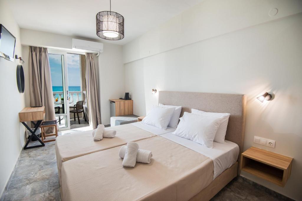 a bedroom with a large bed with a view of the ocean at Birais Beach Studios in Rethymno