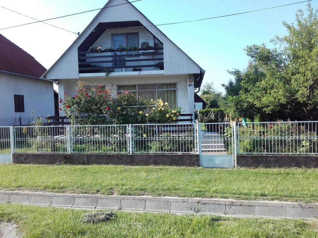 una cerca blanca frente a una casa en János Nyaraló en Balatonmáriafürdő