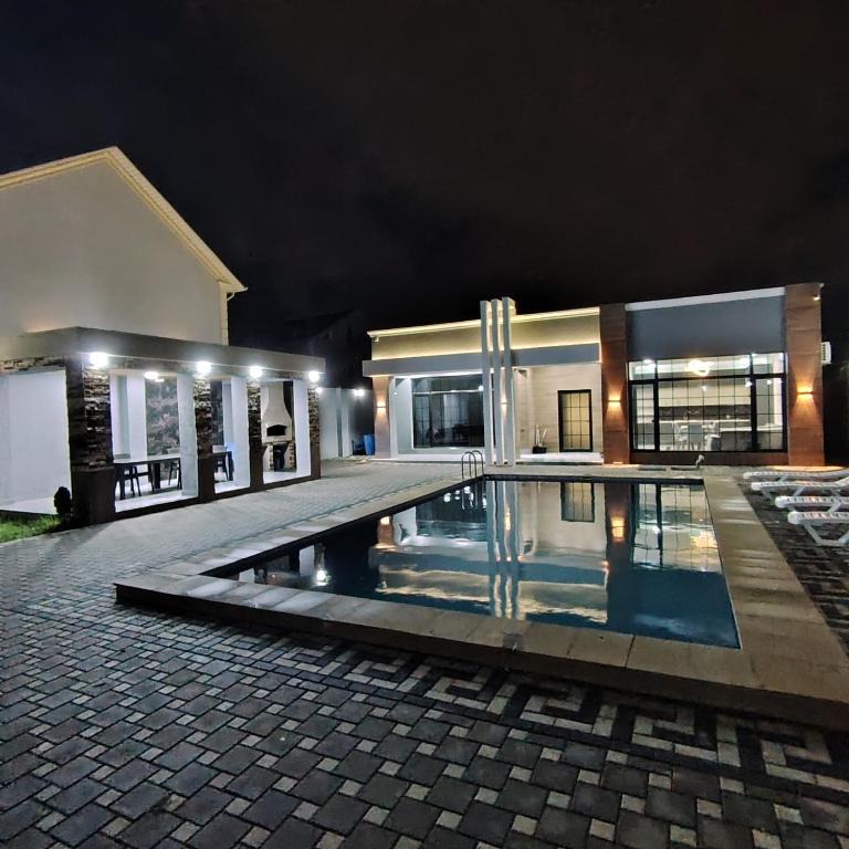 une maison avec piscine la nuit dans l'établissement Warm pool Suvalan, à Baku