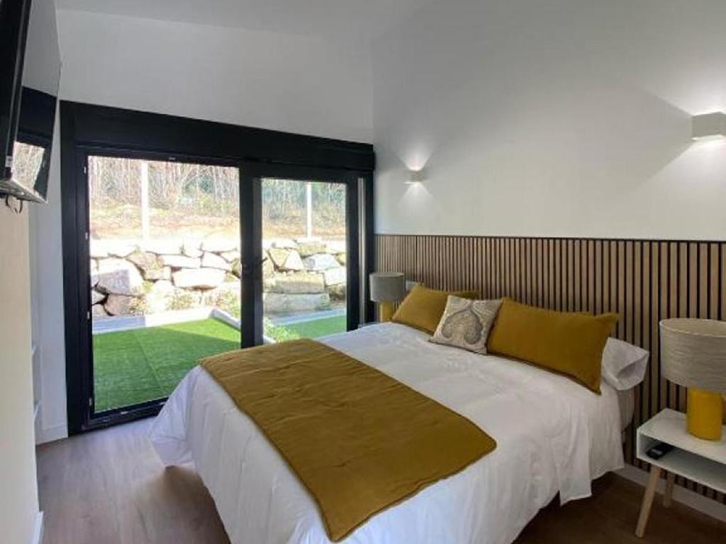 a bedroom with a large bed and a large window at Resort Natur O Grove in O Grove