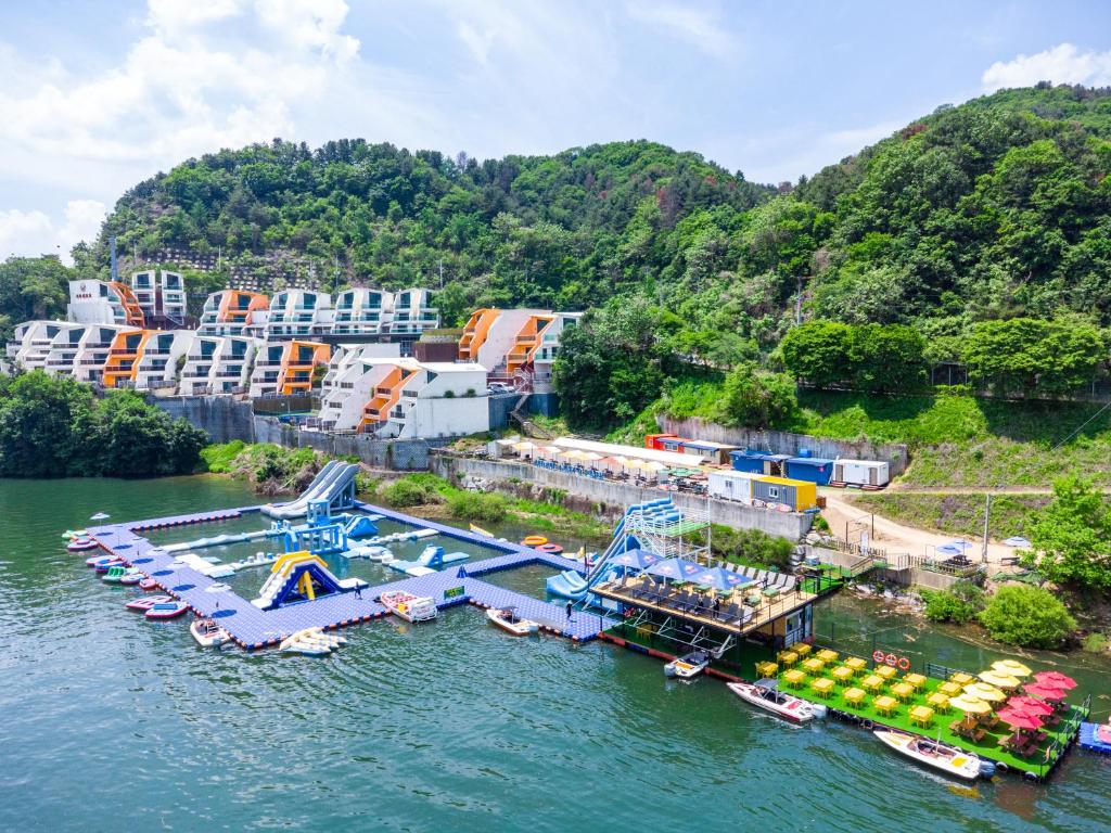 an aerial view of a dock in the water with boats at W Jiwoo Resort in Gapyeong