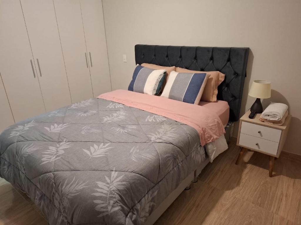 a bedroom with a bed and a night stand with a phone at Hermoso departamento cerca a parque y estadio nacional con cochera in Lima