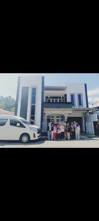 um grupo de pessoas em pé em frente a um prédio em Andhiny homestay em Kejajar