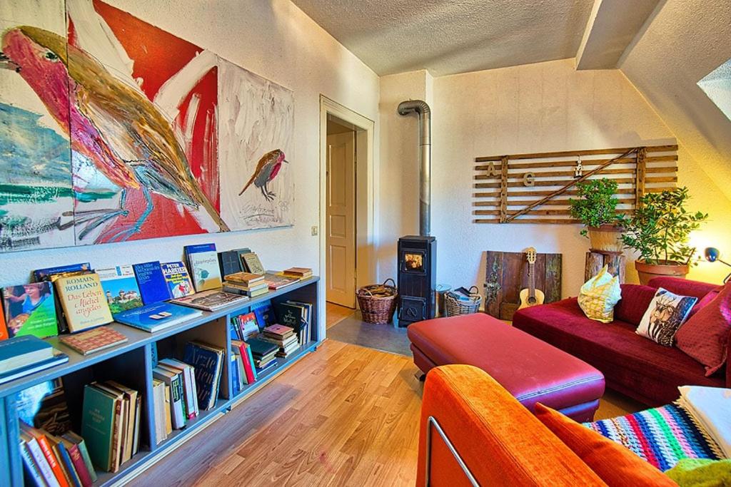 a living room with a couch and a book shelf with books at KUNSTLOFT - Atelier der Auszeit in Marienberg