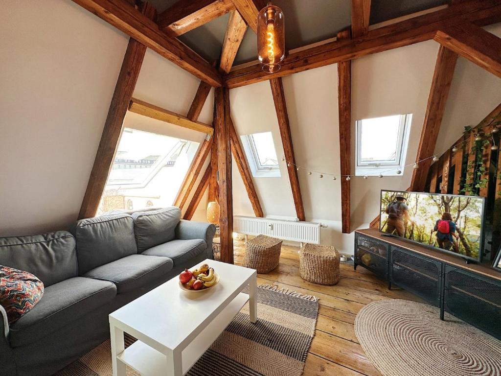Una sala de estar con un sofá y un televisor. en Dornröschenloft, en Marienberg