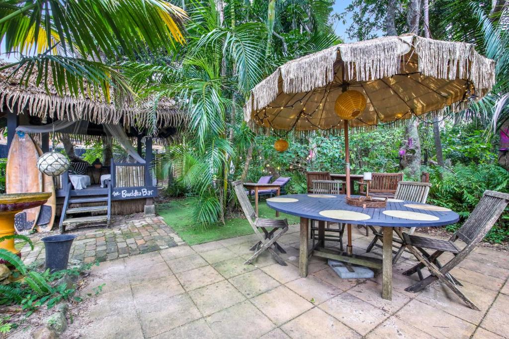 a table and chairs under an umbrella on a patio at Shellies Twin Beach Houses in Sawtell