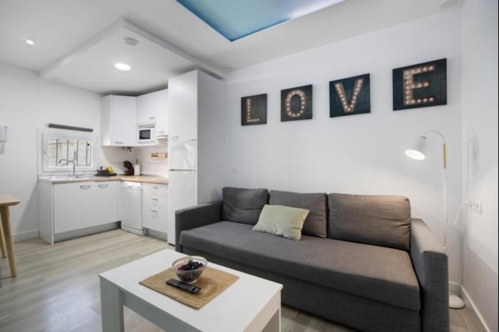 ein Wohnzimmer mit Sofa und Tisch in der Unterkunft La Terraza by Staycare in Rota