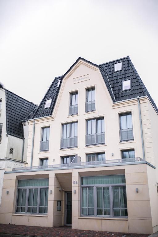 诺德奈Haus NordQuartier的一座黑色屋顶的白色大楼