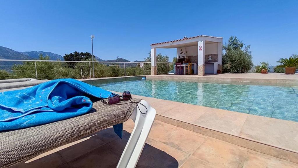 ein Korbbett mit einer blauen Decke neben einem Swimmingpool in der Unterkunft Villa 62 by Villamya in El Gastor