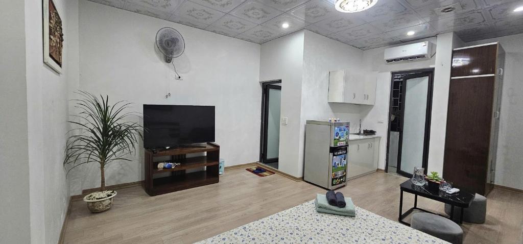 a living room with a flat screen tv and a kitchen at Bu studio 46 Nam Ngư in Hanoi