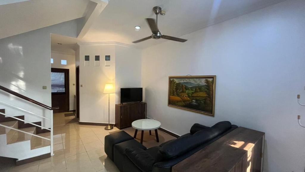 a living room with a couch and a table at Schonen House by Ruby Living in Yogyakarta