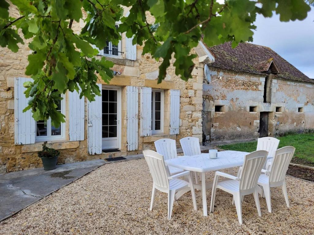 ein weißer Tisch und Stühle vor einem Gebäude in der Unterkunft Lake House A Tranquil Escape in Lescuretie