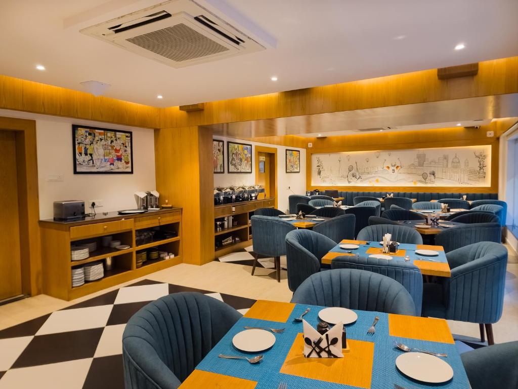 a restaurant with blue chairs and tables in a room at Hotel Metro Prime in Kolkata