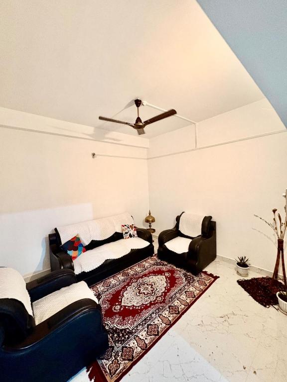 a living room with two couches and a rug at Puspalay Homestay in Guwahati