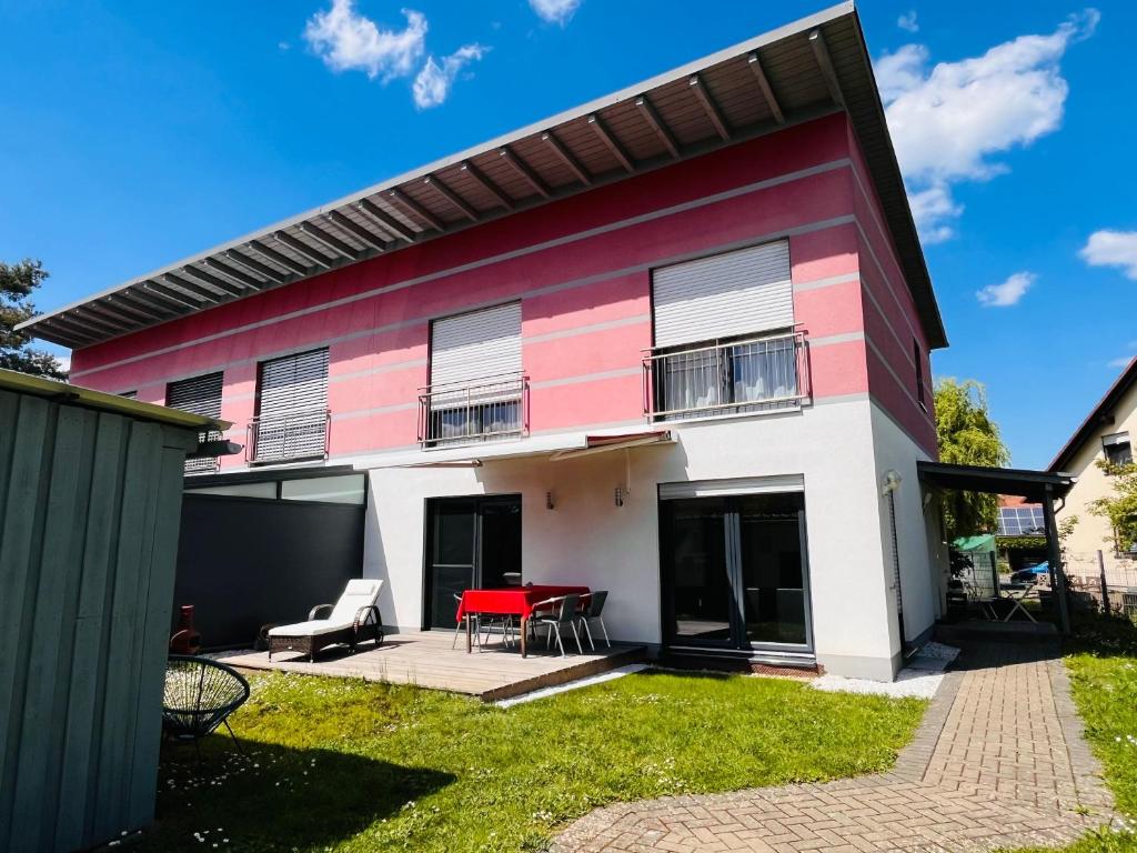 ヒルシャイトにあるFerienhaus Fei schö Hirschaidの赤と白の家(パティオ付)