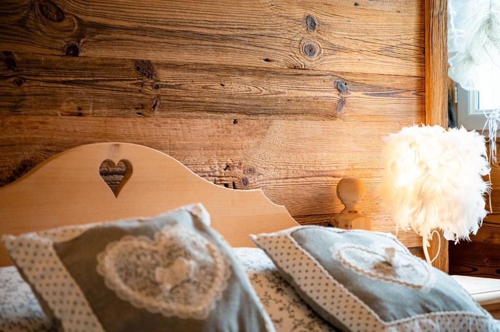 ein Schlafzimmer mit einer Holzwand und einem Bett mit Kissen in der Unterkunft La Petite Chaumière avec sauna in Saint-Maurice-sur-Moselle