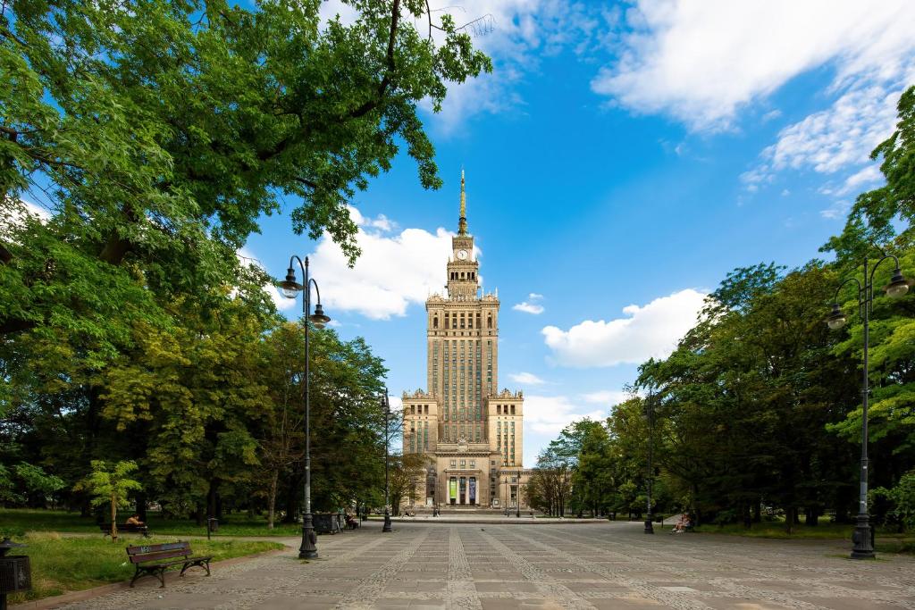 a large building with a tower on top of it at Spacious and Bright Apartment with Parking in the City Center by Noclegi Renters in Warsaw