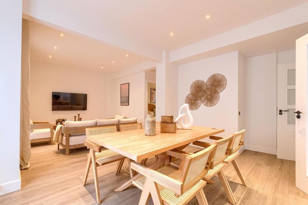 a dining room with a wooden table and chairs at San Mamés Apartment in Bilbao