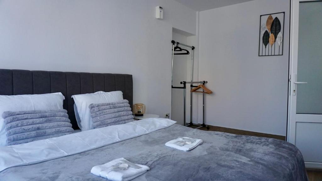 a bedroom with a large bed with towels on it at Chic and sunny downtown apartment in Braşov