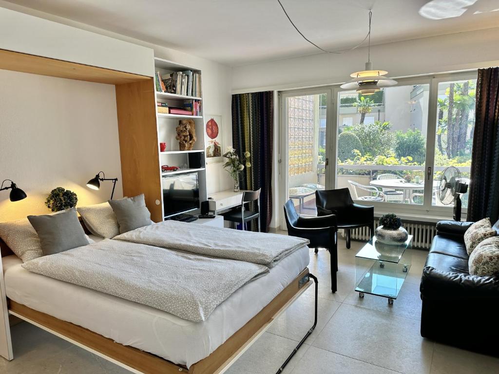 a bedroom with a bed and a living room at Palme 004 by Fewotessin in Locarno