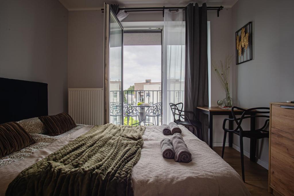a bedroom with a bed with slippers on it at ROOM, Prymasa 1000-lecia in Rzeszów
