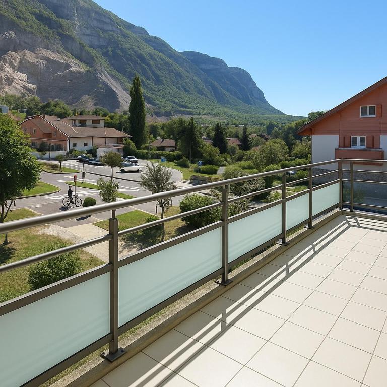 einen Balkon mit Blick auf eine Straße und die Berge in der Unterkunft Comfortable and bright bedroom, in Étrembières