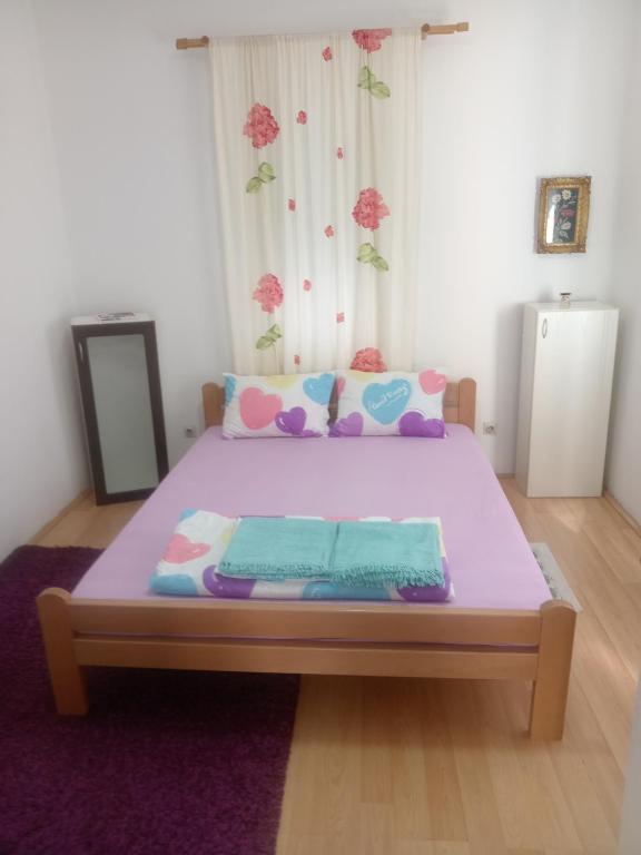 Un dormitorio con una cama morada con una manta morada. en Palamar, en Kuršumlija