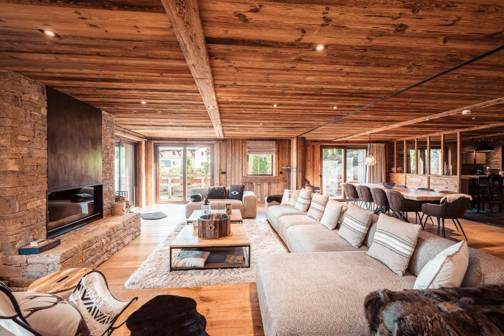 a living room with couches and a fireplace at Belmont - New & ecological chalet in the heart of Combloux in Combloux