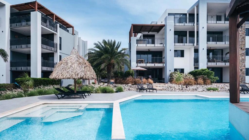 a swimming pool in front of a building at Holland House - Cape Marie 1401 in Willibrordus
