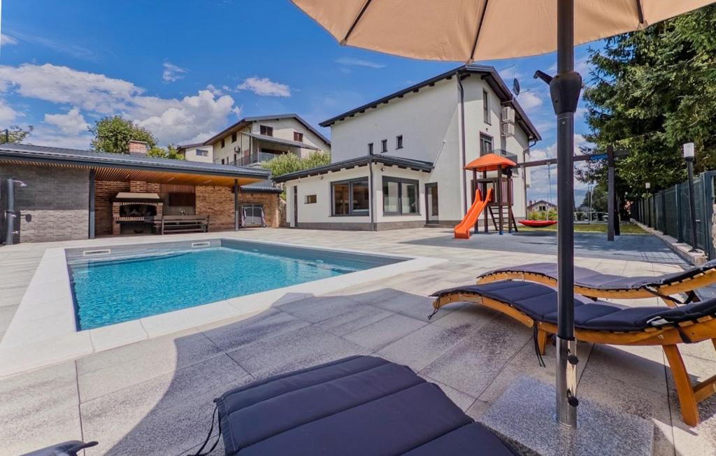 una piscina con dos tumbonas y una sombrilla en Villa Tia by Villas Guide, en Karlovac