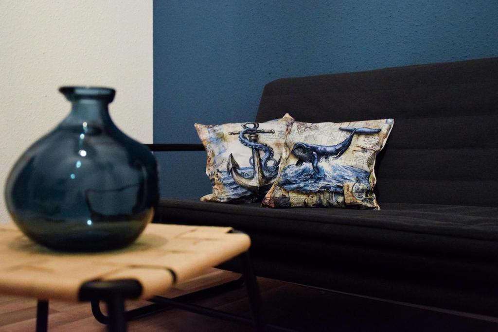 Un jarrón sobre una cama junto a una mesa. en Große Wohnung in der KTV, en Rostock